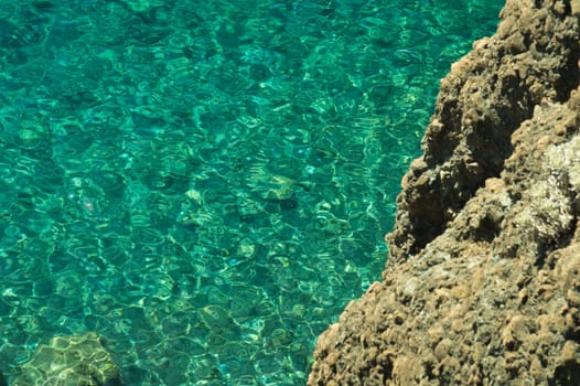 Mountain and sea. transparent water. rocky cliff background