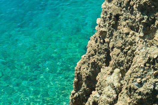 Mountain and sea. transparent water. rocky cliff background