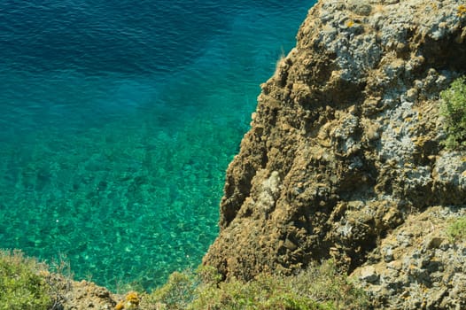 Mountain and sea. transparent water. rocky cliff background