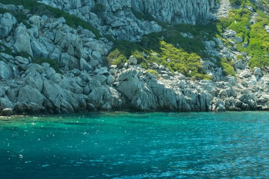 Mountain and sea. coastline with the overgrown rock background