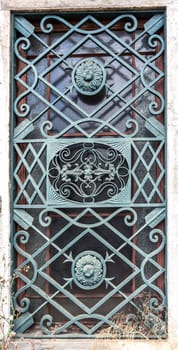 Detail of the elaborated iron grill covering the windows of each side of the entrance portal of the Palace Condes da Ponte built in early 18th century in Alcantara, Lisbon, Portugal