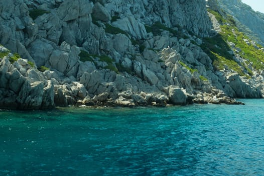 Mountain and sea. coastline with the overgrown rock background