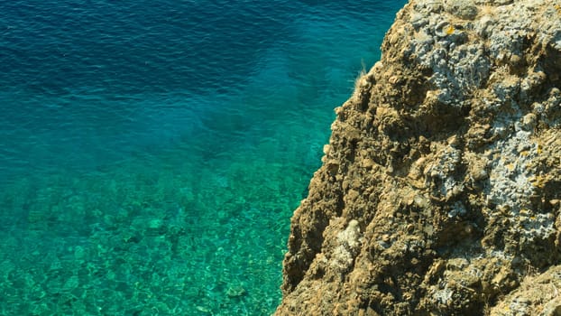 Mountain and sea. transparent water. rocky cliff background
