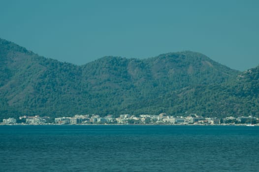 Nature landscape with a city by the shore of the sea between the hills. mountain town panoramic view