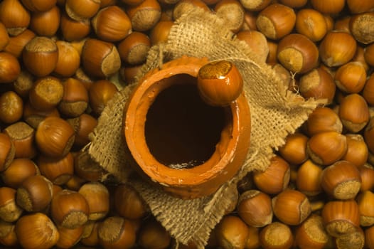 Honey pot with wooden spoon and nuts background