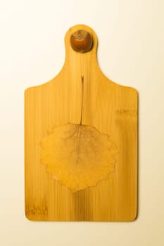 Hazelnut and autumn leaf on a wooden board background