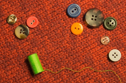 Various sewing buttons with the threads on textile background. copy space