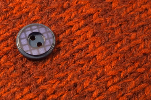 Button on red textile background. macro view. copy space