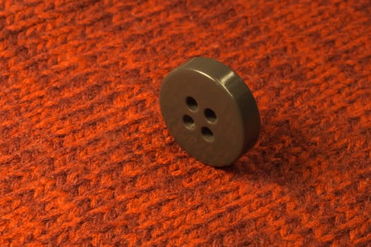 Button on red textile background. macro view. copy space