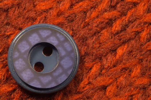 Button on red textile background. macro view. copy space