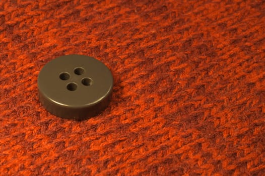 Button on red textile background. macro view. copy space