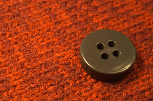 Button on red textile background. macro view. copy space