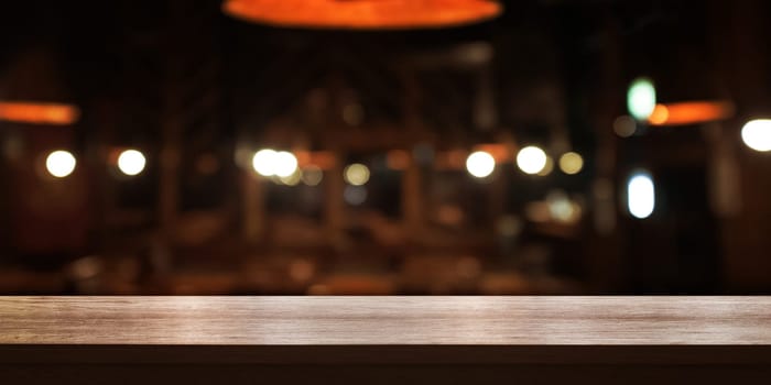 Empty wooden table top with blur coffee shop or restaurant interior background, Panoramic banner. Abstract background can be used for display or montage your products.