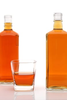 Glass cup and bottle of whiskey on white background
