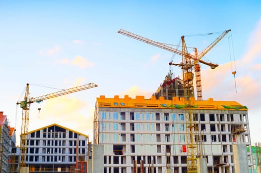 Cranes working at construction site of modern apartments building, real estate business, Kiev, Ukraine
