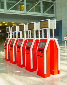 FRANKFURT AM MAIN, GERMANY - AUGUST 29, 2018: Red machines for self service at checkpoint in hall of Frankfurt airport, Germany