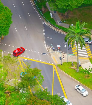 Aerial view of road traffic in Singapore. People crossing the road