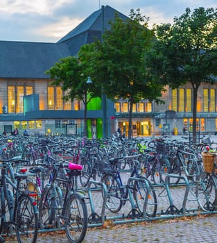 Big bicycles parking by train station in susnet dusk, Dortmund, Germany
