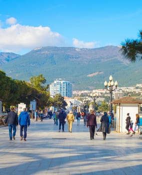 YALTA, CRIMEA, UKRAINE - APRIL 03, 2018: People walking by Yalta promenade in sunny day. Yalta is the most famous tourist destination in Crimea