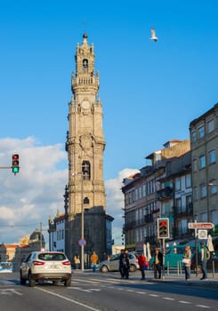 PORTO, PORTUGAL - NOVEMBER 22, 2016: Bell tower (Torre dos Clerigos), people crossing road with car traffic
