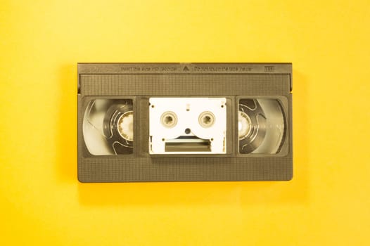 Video cassette on yellow background. mini cassette. copy space