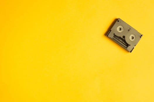 Digital video cassette on yellow background. mini cassette. copy space