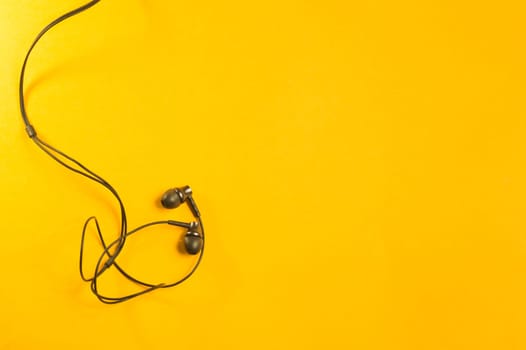 Earphones isolated on yellow background. copy space