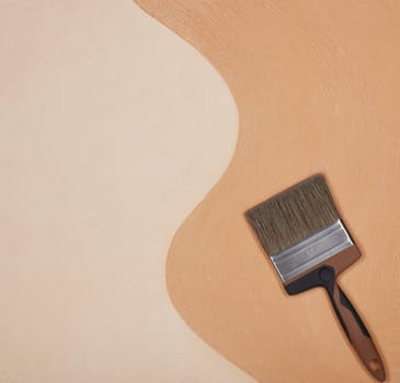 Paint brush on textural double background consisting of two beige shades. Top view with copy space, Concept of construction or design office
