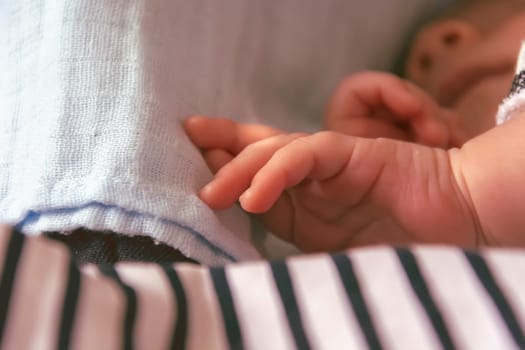 Close-up view of the hands of a sleeping newborn child. Concept of childhood and serenity