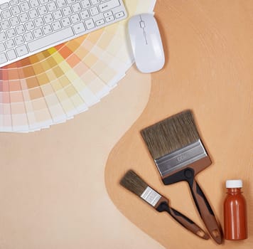 Painting accessories and computer keyboard lying on textural double background consisting of two beige shades. Top view with copy space, Concept of construction or design office. Internet shop