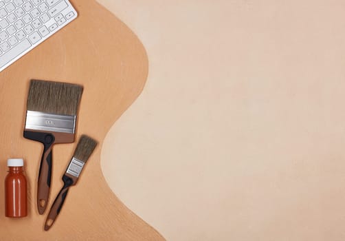 Painting accessories and computer keyboard lying on textural double background consisting of two beige shades. Top view with copy space, Concept of construction or design office. Internet shop