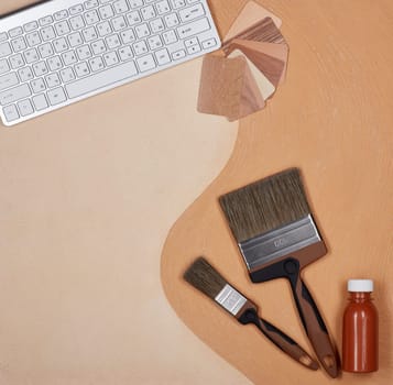 Painting accessories and computer keyboard lying on textural double background consisting of two beige shades. Top view with copy space, Concept of construction or design office. Internet shop
