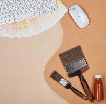 Painting accessories and computer keyboard lying on textural double background consisting of two beige shades. Top view with copy space, Concept of construction or design office. Internet shop
