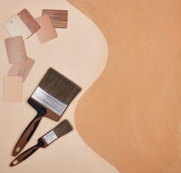 Texture and colour swatches and painting accessories ( paint brushes) on textural double background consisting of two beige shades. Top view with copy space, Concept of construction or design office