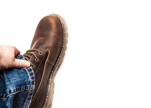 Men's brown boots and blue jeans. Isolated on white bacground