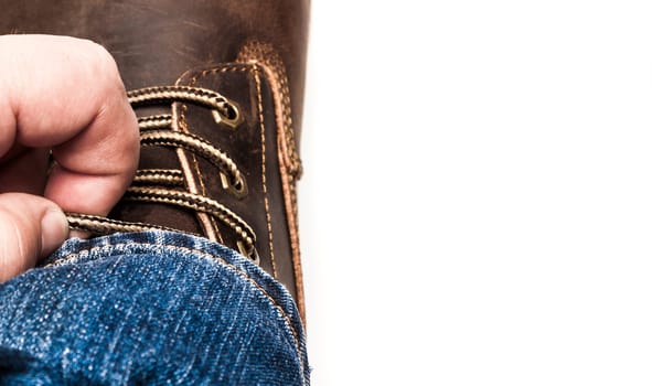 Men's brown boots on stone gravel background. Closeup isolated