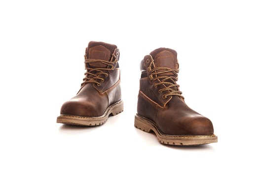 Men's brown boots on stone gravel background. Closeup isolated