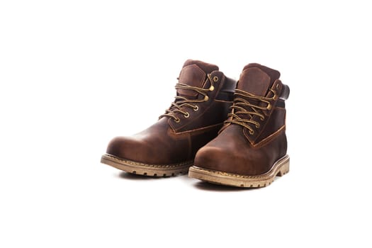Men's brown boots on stone gravel background. Closeup isolated
