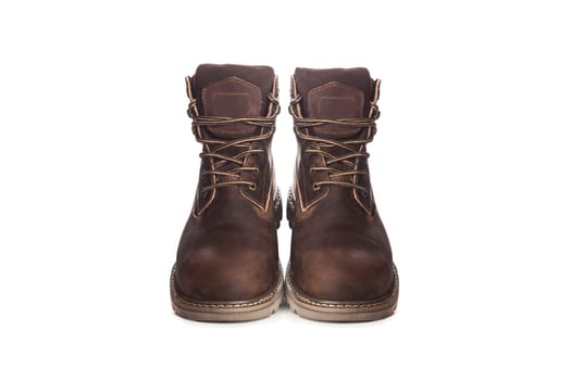 Men's brown boots on stone gravel background. Closeup isolated