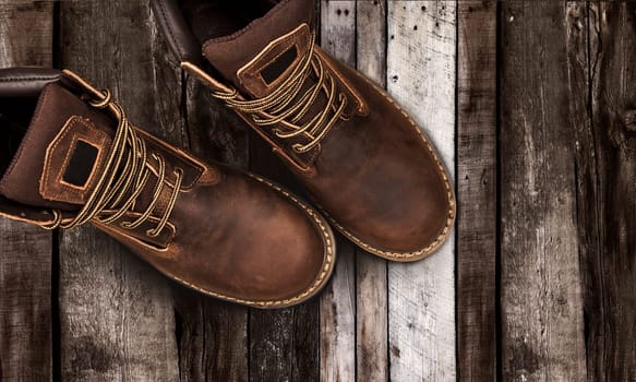 Men's brown boots on stone gravel background. Closeup isolated