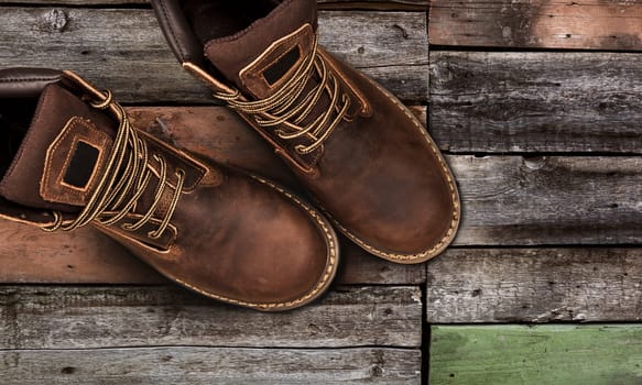 Men's brown boots on stone gravel background. Closeup isolated