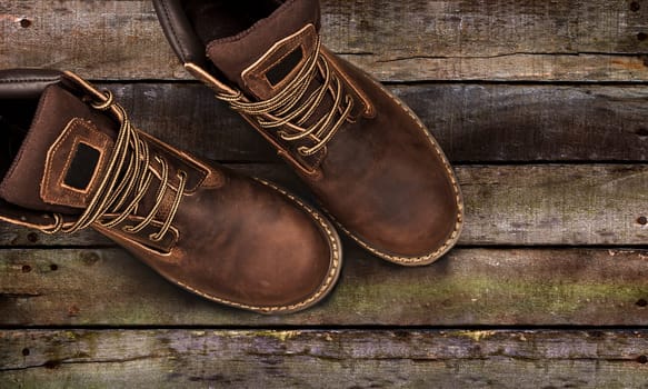 Men's brown boots on stone gravel background. Closeup isolated