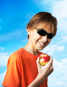 Portrait casual young man eating apple, against a white wall