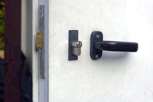 Black handle with lock at metal door