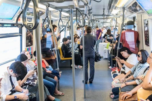 Bangkok, Thailand, - Mar 5, 2019: Passenegers using their mobile phone devices while commuting by city metro in Bangkok, Thailand on 5th of March, 2019.