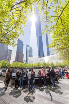 New York City, USA - May 18, 2018: People visiting 9 11 memorial park in downtown Manhattan, located on the site as the original World Trade Center, on 18th of May, 2018, New York City, USA.