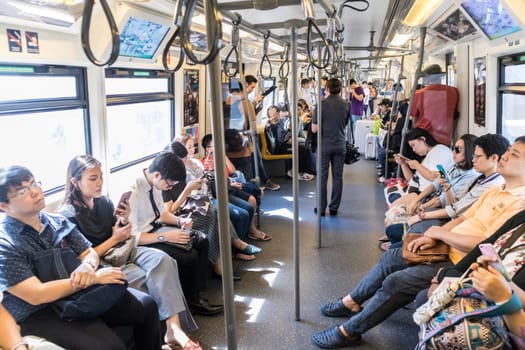 Bangkok, Thailand, - Mar 5, 2019: Passenegers using their mobile phone devices while commuting by city metro in Bangkok, Thailand on 5th of March, 2019.