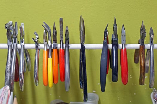 Various small pliers craft tools at rail
