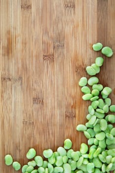 Fresh raw lima beans on cutting board with copy space.