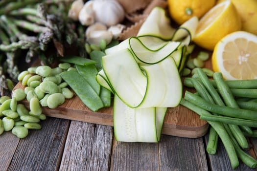 Fresh ingredients for pasta, zucchini, lima beans, green beans, lemon, garlic and homemade whole wheat pappardelle pasta.